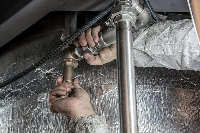 Plumber repairing shower pipes